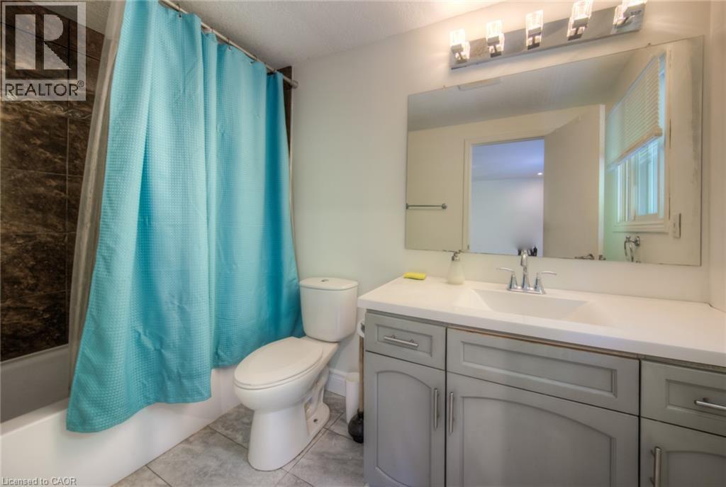 Bathroom with shower / bath combo with shower curtain, vanity, and light tile patterned floors - 20 Bankside Drive, Kitchener, ON - Indoor Photo Showing Bathroom