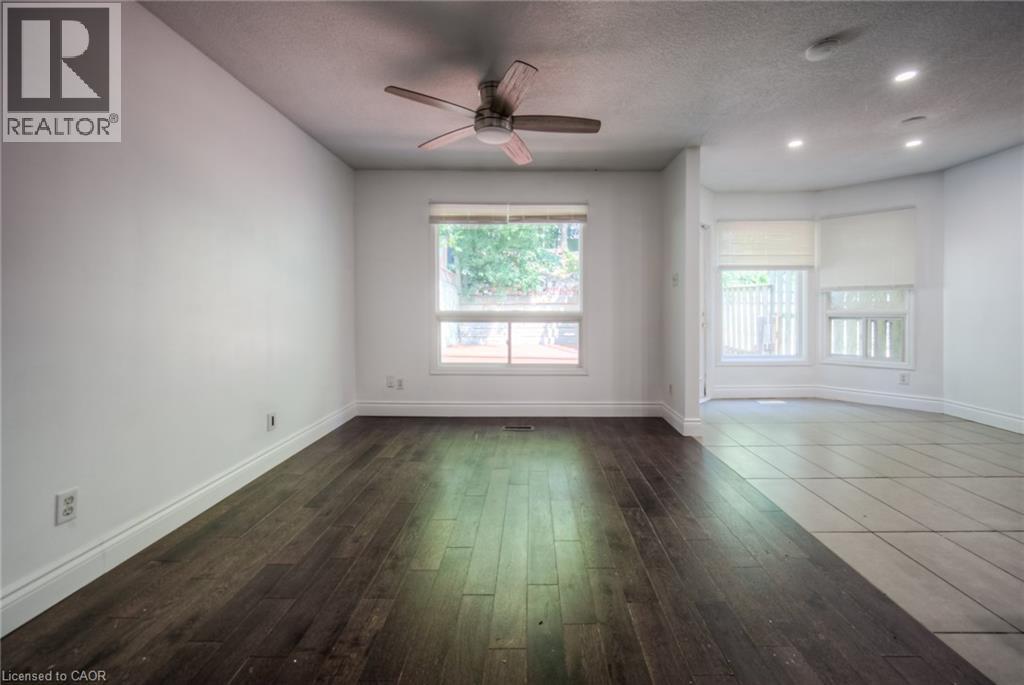 Spare room featuring dark wood-style floors, a textured ceiling, healthy amount of natural light, ceiling fan, and recessed lighting - 20 Bankside Drive, Kitchener, ON - Indoor Photo Showing Other Room