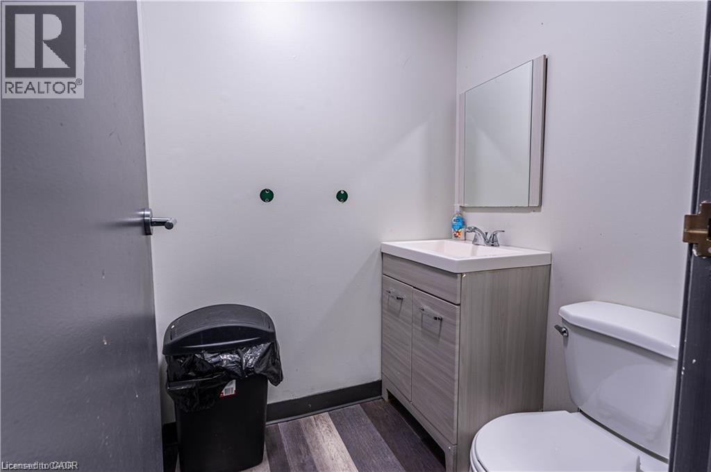 Half bathroom featuring vanity and dark wood-type flooring - 10 Main Street, Mississauga, ON