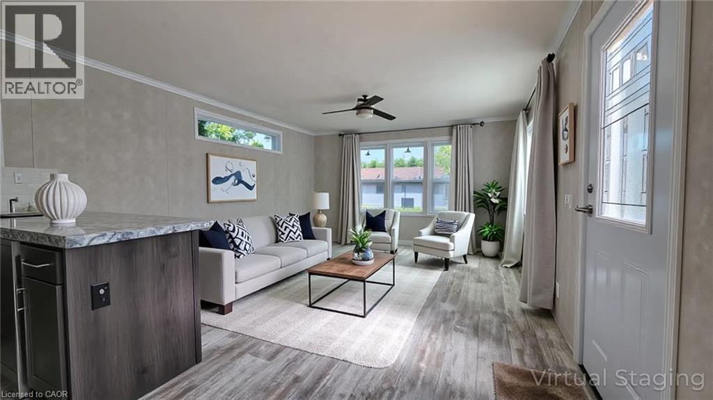 Living room with crown molding, light wood finished floors, and a ceiling fan - 24 Macpherson Crescent, Flamborough, ON - Indoor Photo Showing Living Room