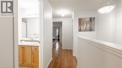Corridor with baseboards, dark wood finished floors, and a sink -