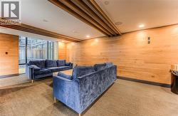 Carpeted living room featuring beamed ceiling and wood walls -