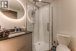 Bathroom with vanity, an enclosed shower, and toilet -