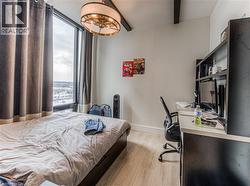 Bedroom with beam ceiling and light hardwood / wood-style floors -