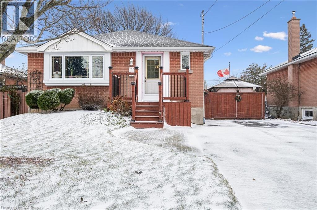 View of front of property with brick siding, a gate, and roof with shingles - 263 East 36Th Street, Hamilton, ON - Outdoor
