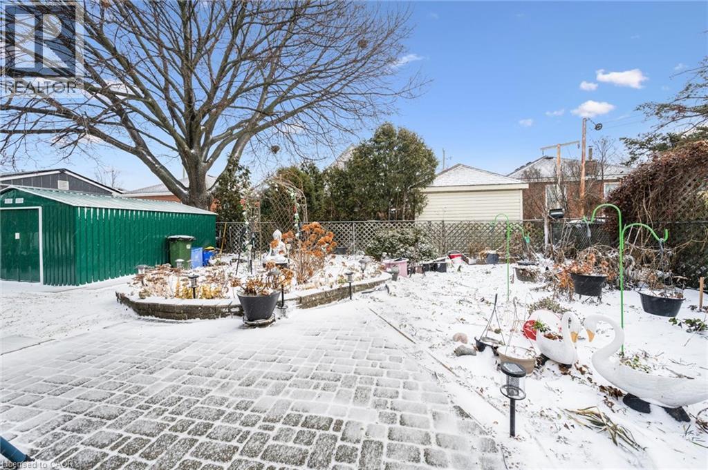 View of community with a fenced backyard, a patio, and a storage shed - 263 East 36Th Street, Hamilton, ON - Outdoor