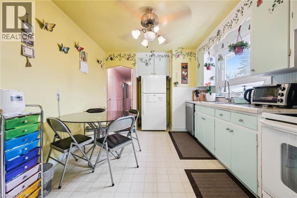 Kitchen featuring light floors, white appliances, light countertops, ceiling fan, and green cabinetry - 263 East 36Th Street, Hamilton, ON - Indoor Photo Showing Other Room