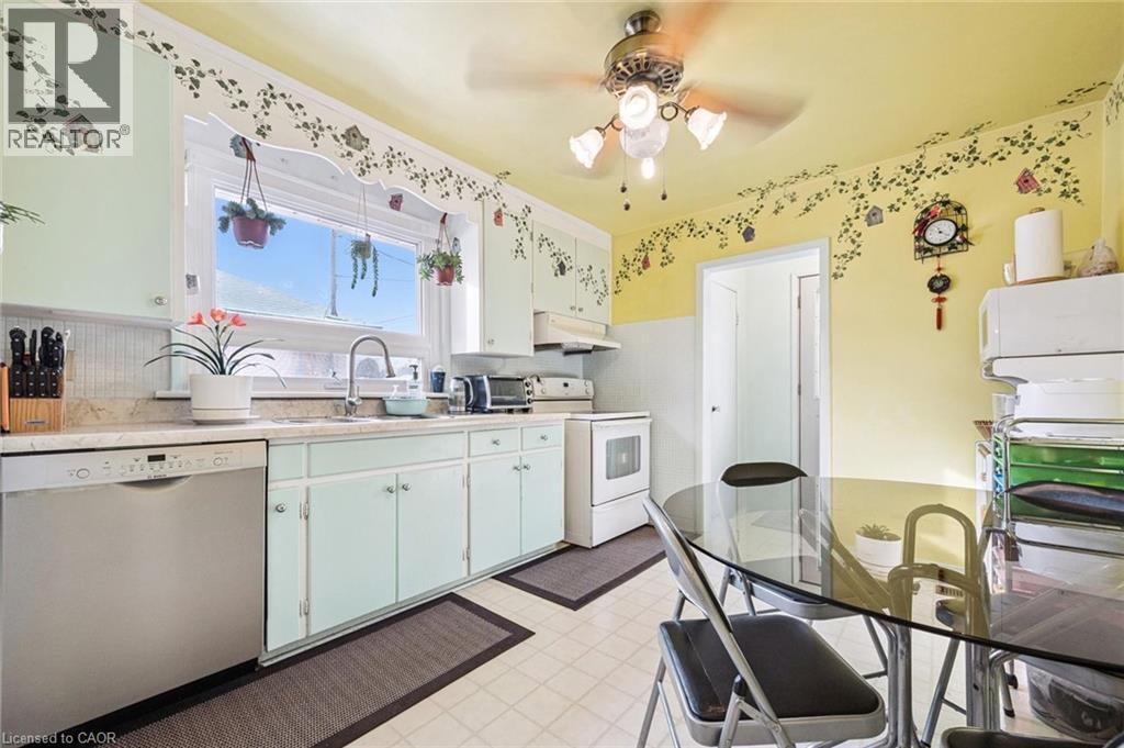 Kitchen with stainless steel dishwasher, light countertops, electric range, light flooring, and a ceiling fan - 263 East 36Th Street, Hamilton, ON - Indoor Photo Showing Kitchen