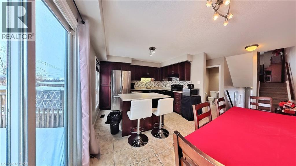 Dining space featuring stairway, light tile patterned floors, and a textured ceiling - 206 Westmeadow Drive, Kitchener, ON - Indoor
