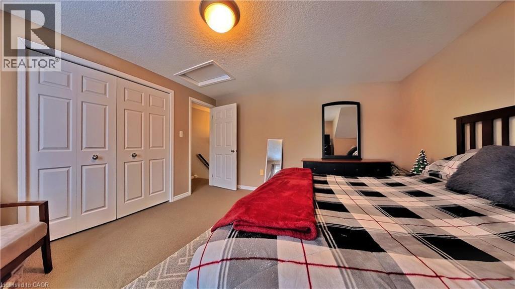 Bedroom featuring attic access, a textured ceiling, a closet, and light colored carpet - 206 Westmeadow Drive, Kitchener, ON - Indoor Photo Showing Bedroom