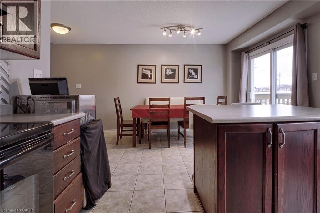 Kitchen with black electric range oven, light countertops, dark brown cabinets, light tile patterned flooring, and a textured ceiling - 206 Westmeadow Drive, Kitchener, ON - Indoor Photo Showing Kitchen