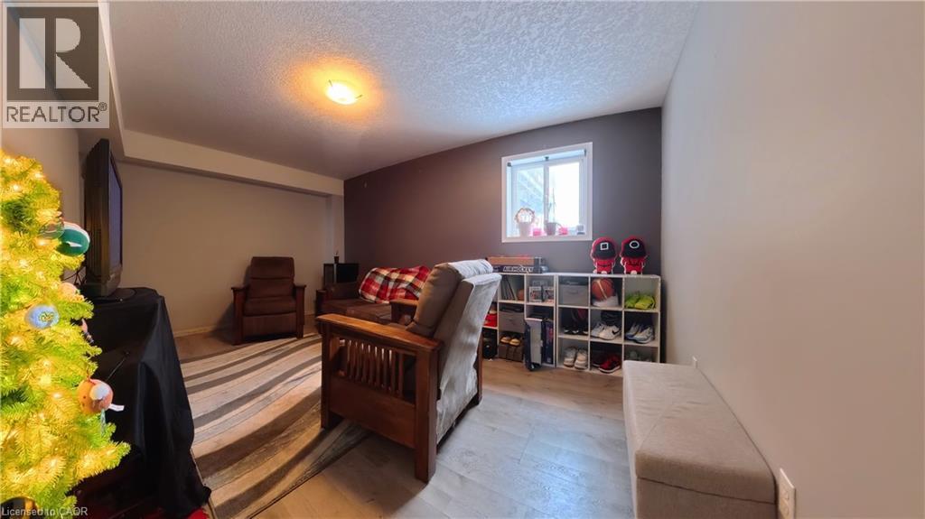 Sitting room featuring a textured ceiling and wood finished floors - 206 Westmeadow Drive, Kitchener, ON - Indoor