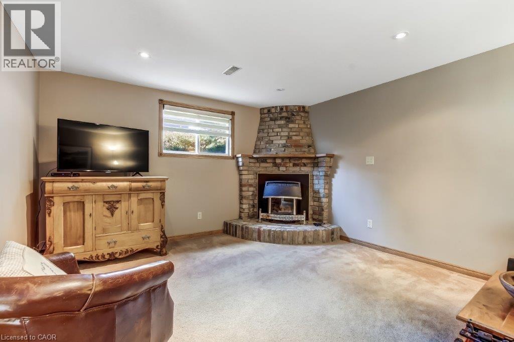 Living room with carpet flooring, a fireplace, and recessed lighting - 2 Falls Crescent, Simcoe, ON - Indoor Photo Showing Living Room With Fireplace