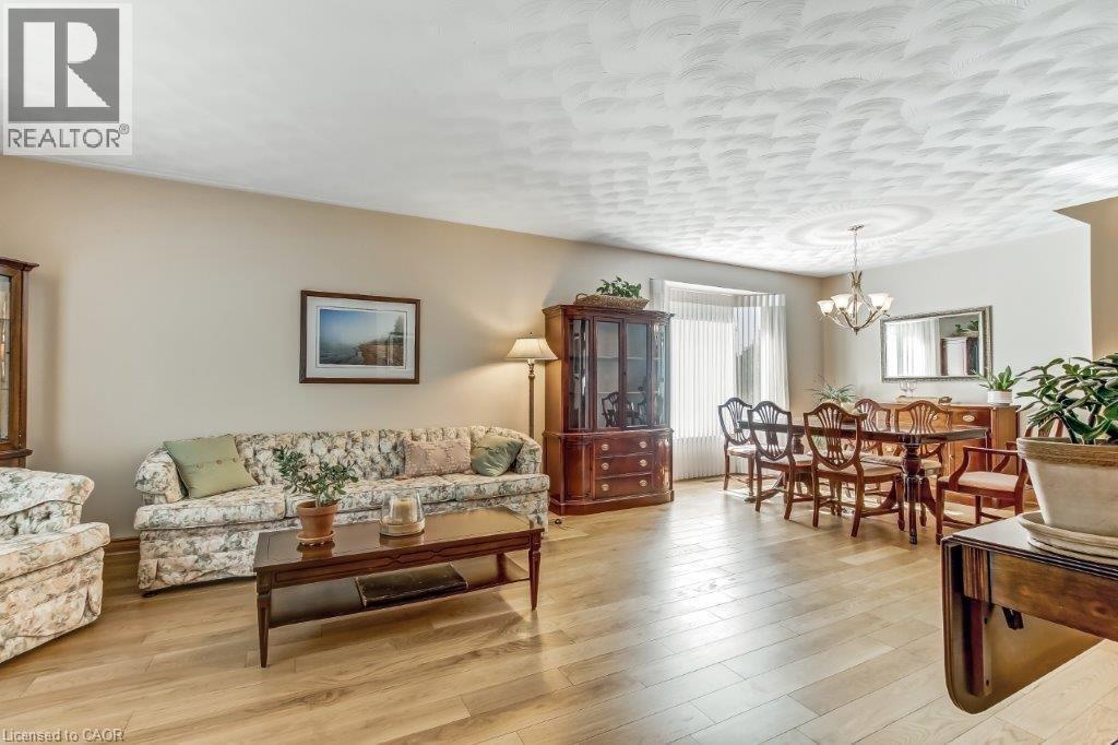 Living area with light wood finished floors and a chandelier - 2 Falls Crescent, Simcoe, ON - Indoor Photo Showing Living Room