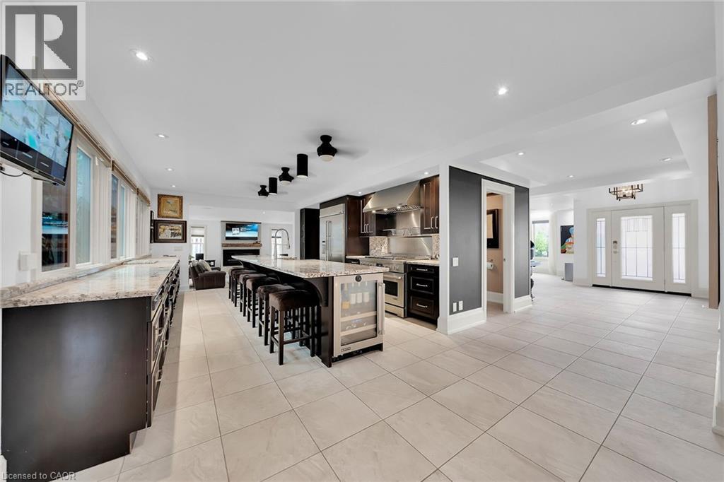 Bar with light tile patterned flooring, light stone countertops, dark brown cabinets, a fireplace, and recessed lighting - 404 Mountain Brow Boulevard E, Hamilton, ON - Indoor Photo Showing Other Room