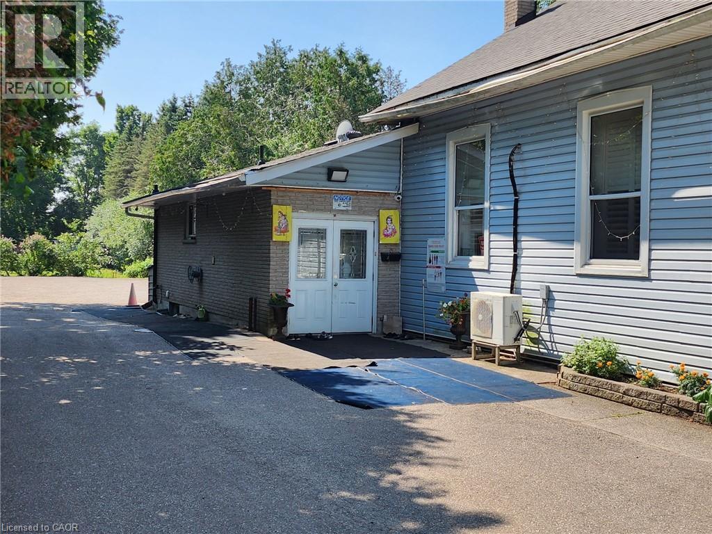 View of front of house with a chimney and brick siding - 67 Old Mill Road, Cambridge, ON
