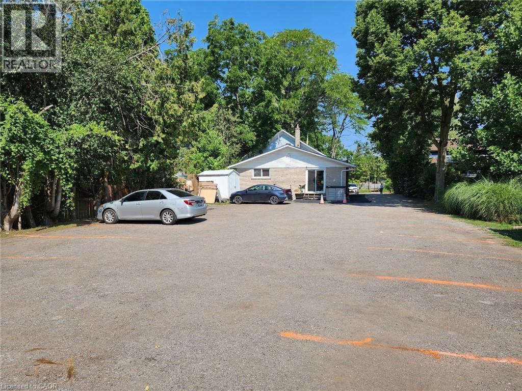 Uncovered parking lot featuring view of wooded area - 67 Old Mill Road, Cambridge, ON