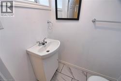 Bathroom featuring vanity and marble look tiles -