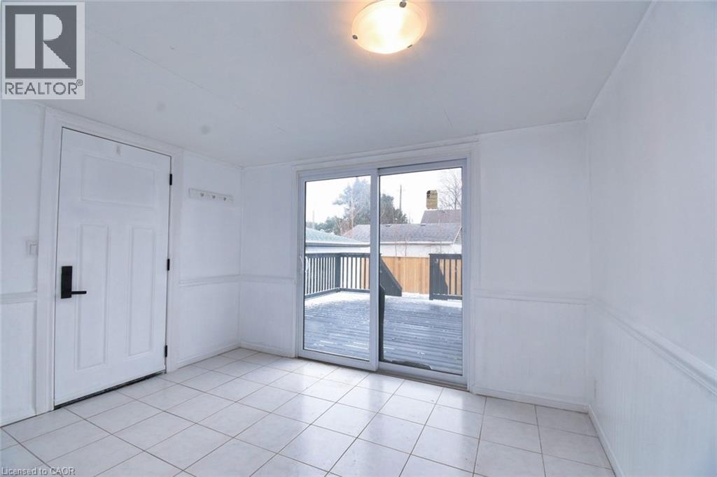 Sunroom featuring light tile patterned floors - 215 Walter Avenue S, Hamilton, ON - Indoor Photo Showing Other Room