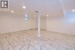 Finished basement with recessed lighting and light marble finish flooring -