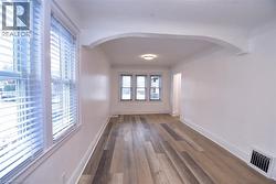 Empty room with wood finished floors and arched walkways -
