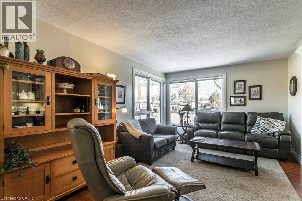 Living room featuring a textured ceiling and dark wood-type flooring - 22 Redwing Road, Hamilton, ON - Indoor Photo Showing Living Room
