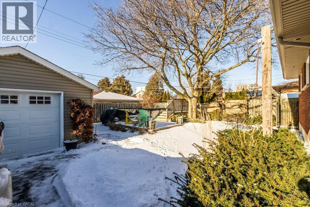 Fenced backyard featuring an Above Ground Pool, patio and a garage - 22 Redwing Road, Hamilton, ON - Outdoor