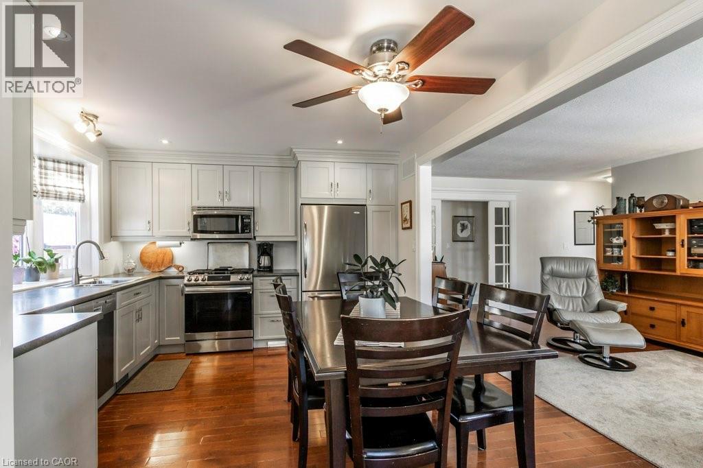 Kitchen with stainless steel appliances, dark wood-style floors, ceiling fan, gray cabinets, and recessed lighting - 22 Redwing Road, Hamilton, ON - Indoor