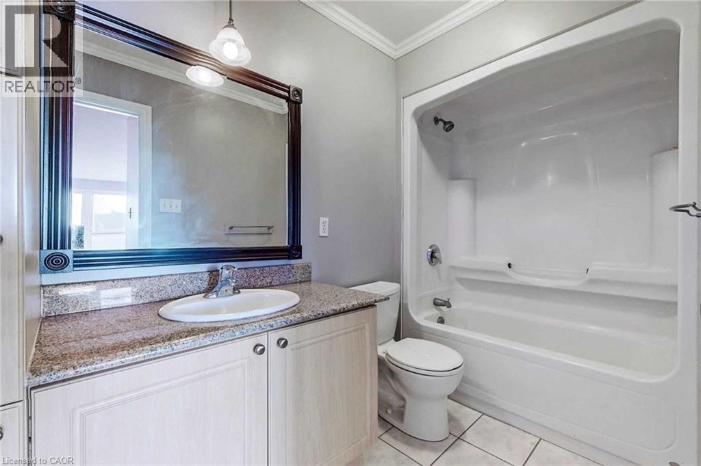 Full bathroom with vanity, bathing tub / shower combination, crown molding, tile patterned flooring, and toilet - 135 James Street Unit# 608, Hamilton, ON - Indoor Photo Showing Bathroom