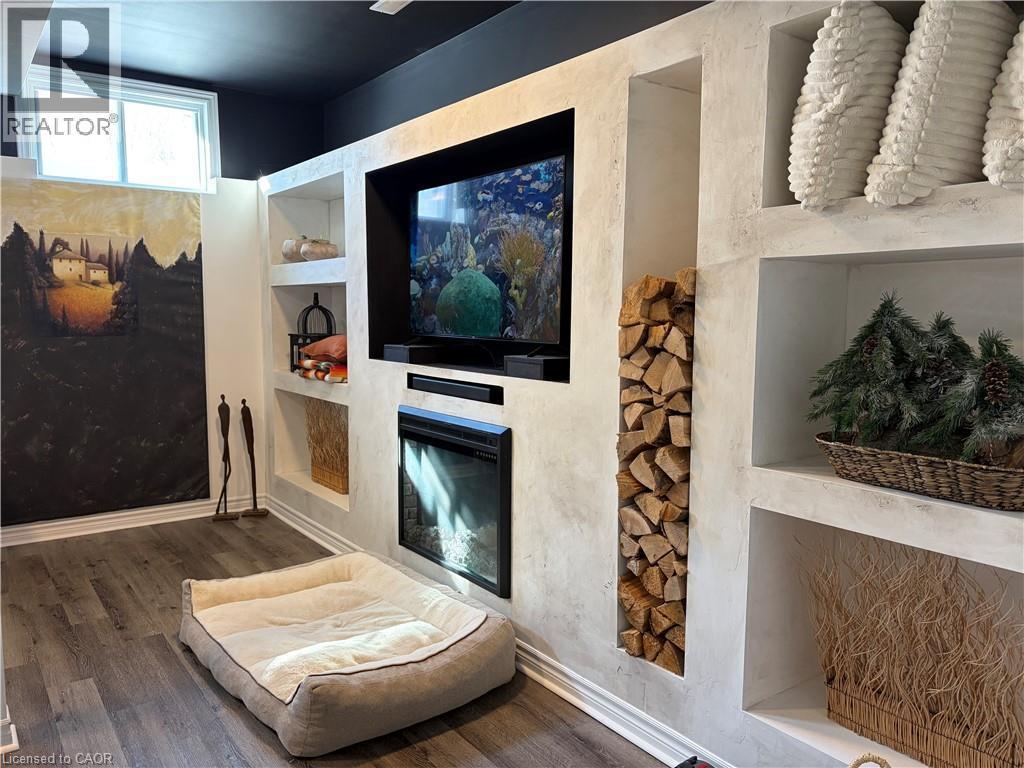 media wall - 657 Windham Road 14, Simcoe, ON - Indoor Photo Showing Other Room With Fireplace