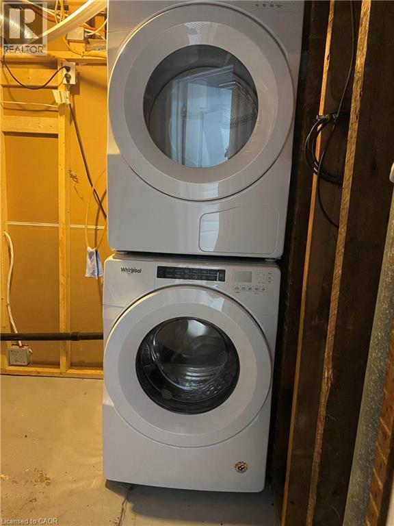 Laundry room with stacked washer / drying machine and concrete flooring - 549 Waterloo Street, Hamilton, ON - Indoor Photo Showing Laundry Room
