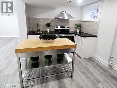 Kitchen with dark countertops, stainless steel electric range oven, tasteful backsplash, and white cabinets - 549 Waterloo Street, Hamilton, ON - Indoor Photo Showing Kitchen