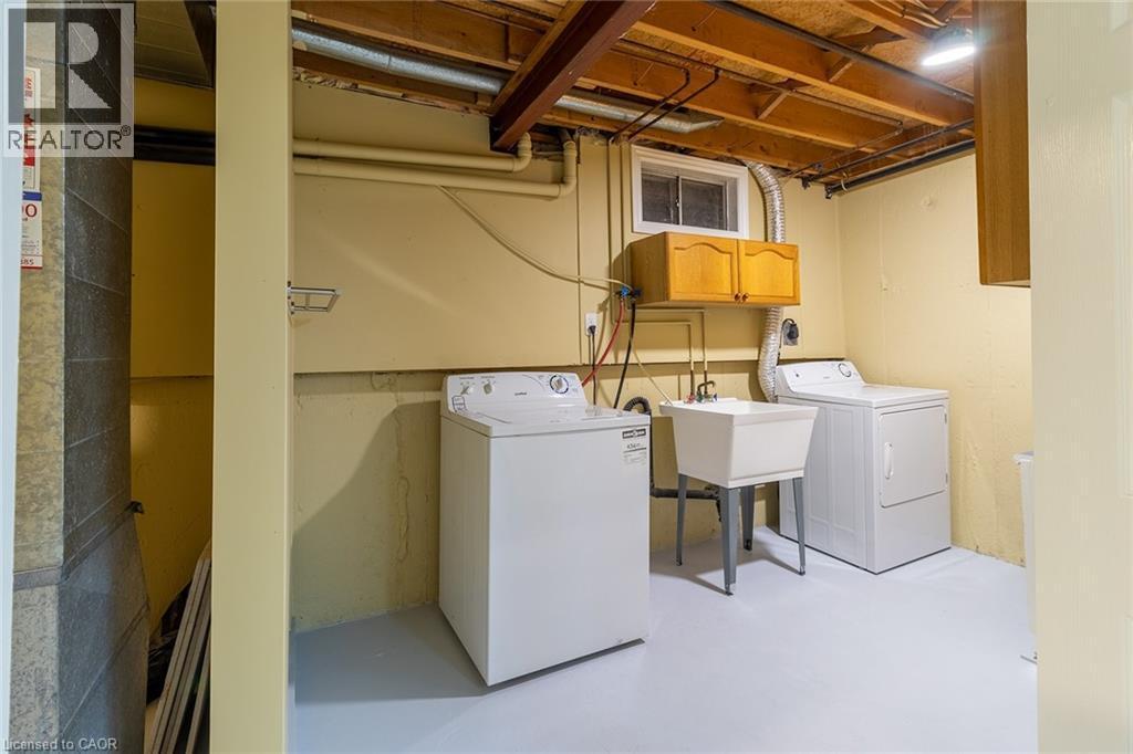 Laundry room with concrete flooring, washer and dryer, and cabinet space - 58 Romy Crescent, Thorold, ON - Indoor Photo Showing Laundry Room