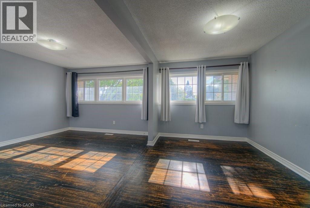 Unfurnished room with a textured ceiling, beam ceiling, and dark wood-type flooring - 46 Guerin Avenue, Kitchener, ON - Indoor Photo Showing Other Room