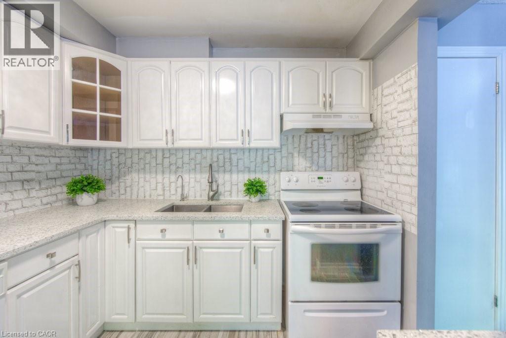 Kitchen with electric range, glass insert cabinets, and white cabinets - 46 Guerin Avenue, Kitchener, ON - Indoor Photo Showing Kitchen With Double Sink