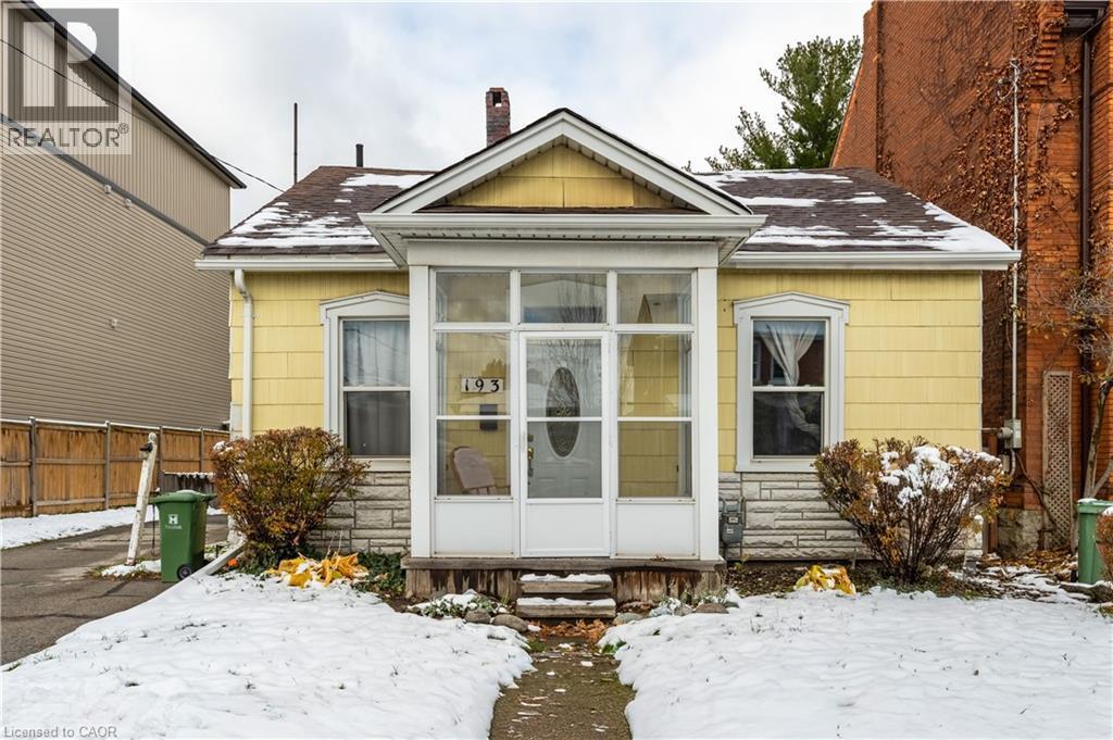 Snow covered rear of property with roof with shingles, a chimney, entry steps, and stone siding - 193 Locke Street N, Hamilton, ON - Outdoor
