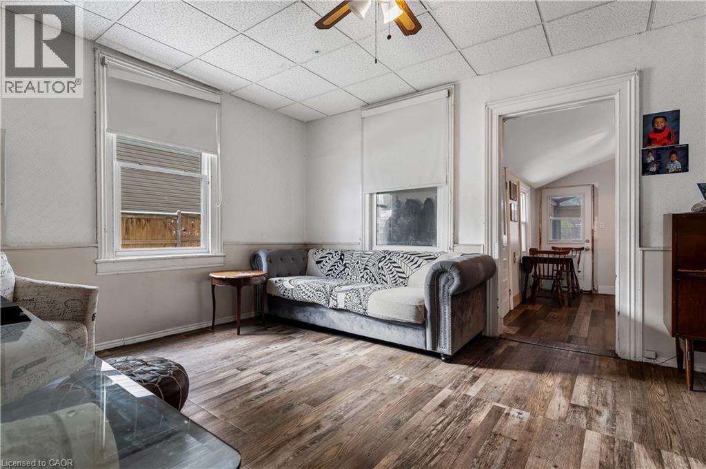 Living room with hardwood / wood-style floors, a ceiling fan, a paneled ceiling, and vaulted ceiling - 193 Locke Street N, Hamilton, ON - Indoor