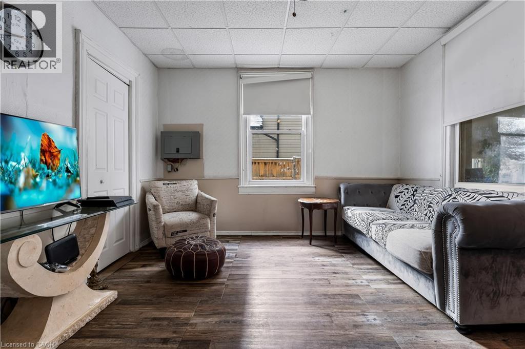 Living area with wood finished floors and a paneled ceiling - 193 Locke Street N, Hamilton, ON - Indoor Photo Showing Living Room
