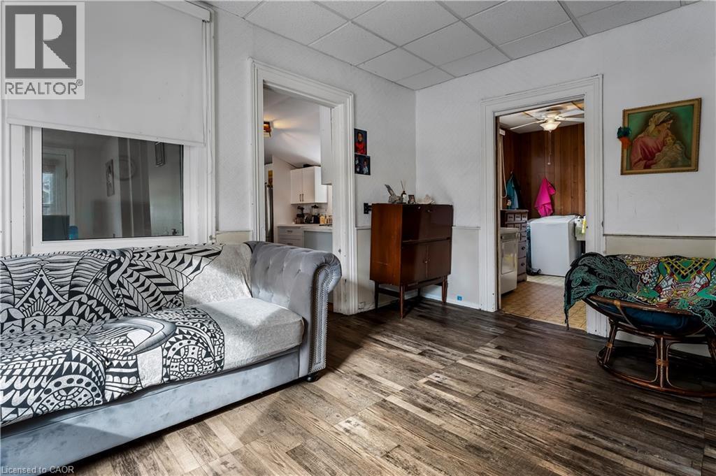 Living area featuring a drop ceiling, wood finished floors, and a ceiling fan - 193 Locke Street N, Hamilton, ON - Indoor