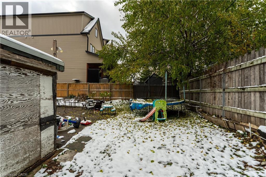 Fenced backyard featuring a trampoline and a patio - 193 Locke Street N, Hamilton, ON - Outdoor