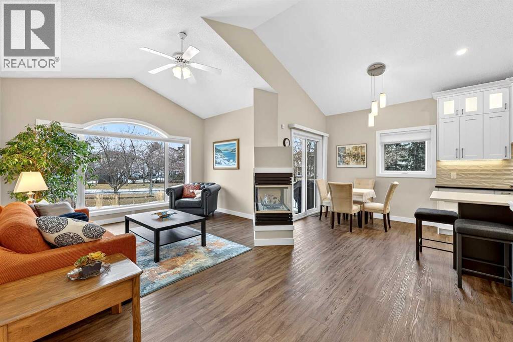 OPEN CONCEPT living, dining and kitchen with 3-sided gas fireplace - 509 Riverview Place Se, Calgary, AB - Indoor Photo Showing Living Room