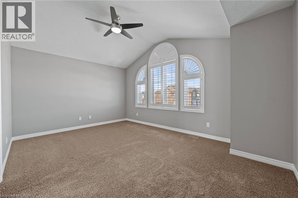 Spare room with visible vents, lofted ceiling, a ceiling fan, carpet floors, and baseboards - 561 Thomas Slee Drive, Kitchener, ON - Indoor Photo Showing Other Room