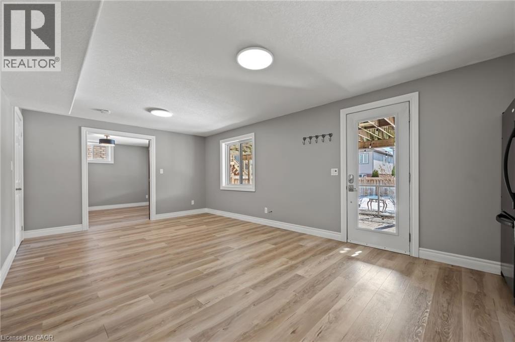 Empty room featuring light wood-style floors, baseboards, and a textured ceiling - 561 Thomas Slee Drive, Kitchener, ON - Indoor Photo Showing Other Room
