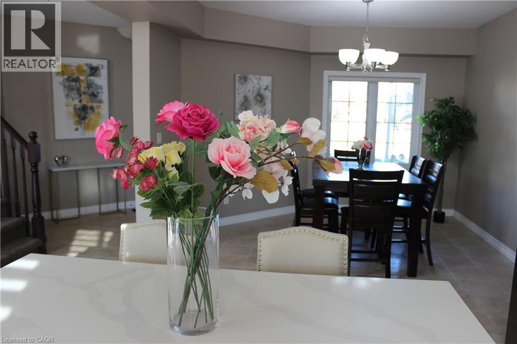 Dining room with light tile patterned flooring, a chandelier, and stairs - 561 Thomas Slee Drive, Kitchener, ON - Indoor Photo Showing Dining Room