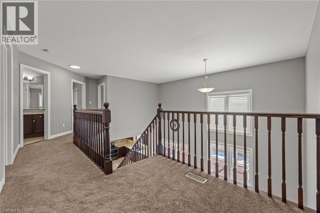 Hallway featuring baseboards, visible vents, carpet floors, a textured ceiling, and an upstairs landing - 561 Thomas Slee Drive, Kitchener, ON - Indoor Photo Showing Other Room