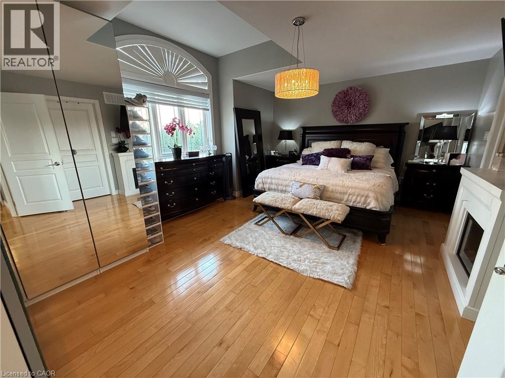 Bedroom featuring light wood-type flooring and a fireplace - 11 Donatello Court, Hamilton, ON - Indoor Photo Showing Bedroom