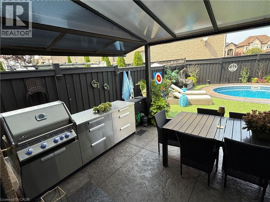 Fenced backyard featuring a patio area, outdoor dining area, and area for grilling - 11 Donatello Court, Hamilton, ON - Outdoor With In Ground Pool With Deck Patio Veranda
