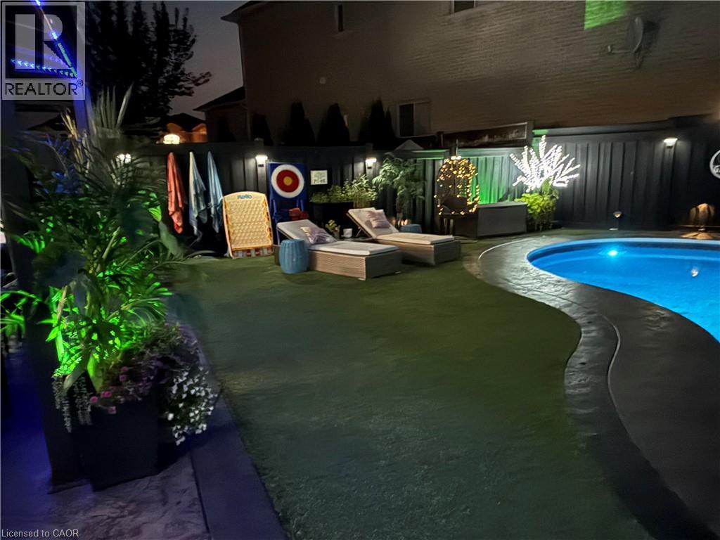 Pool at twilight with a fenced backyard and a patio area - 11 Donatello Court, Hamilton, ON - Outdoor With In Ground Pool