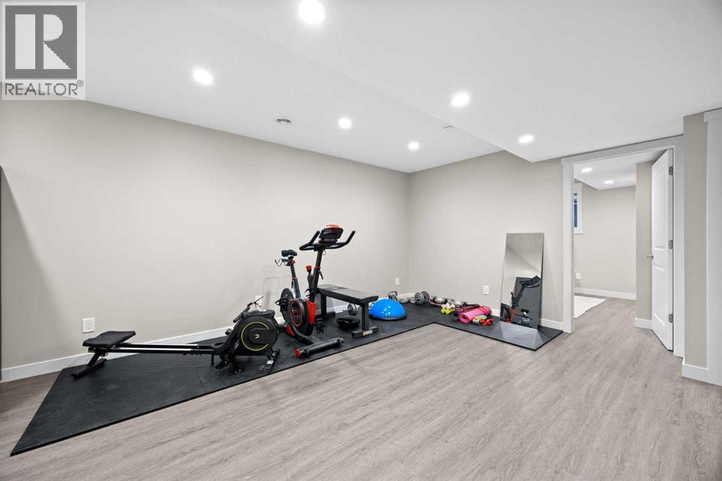 Basement Living Room - 80 Wolf Gate, Okotoks, AB - Indoor Photo Showing Gym Room