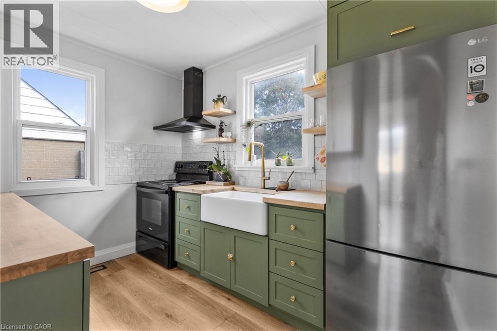 Kitchen featuring green cabinets, butcher block counters, freestanding refrigerator, and open shelves - 191 East 11Th Street, Hamilton, ON - Indoor Photo Showing Kitchen